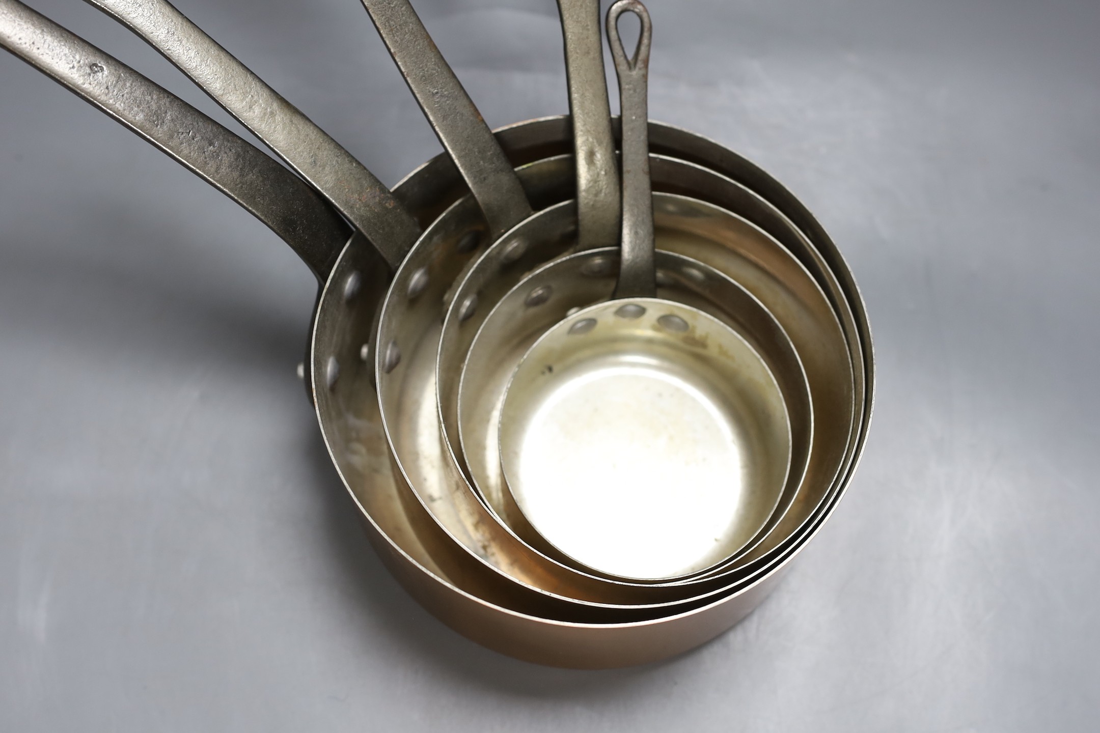 A set of 5 graduated Faucogney copper saucepans